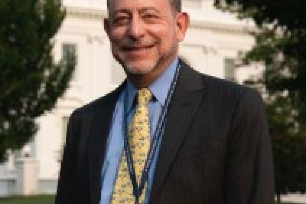 Man in suit standing in front of the White House