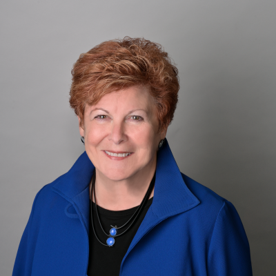 woman with short red hair in a blue suit